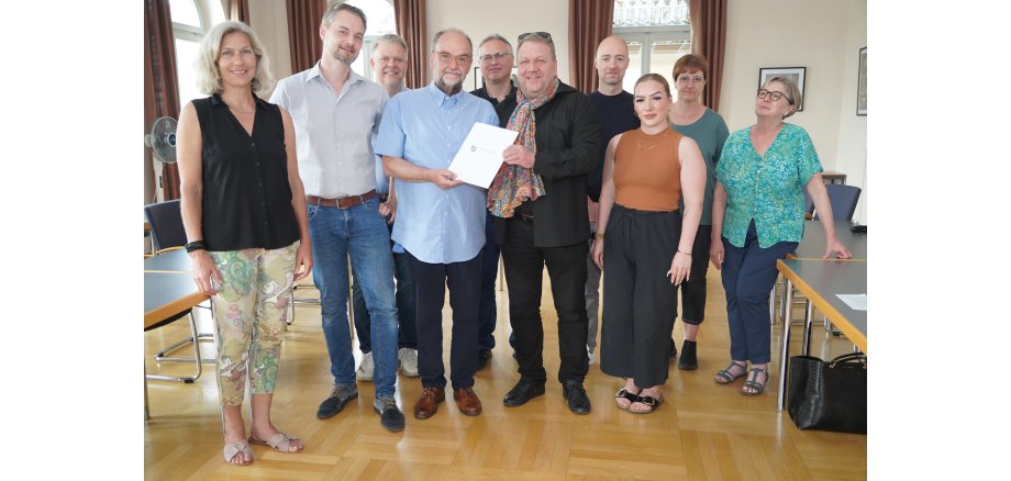 Der hauptamtliche Kreisbeigeordnete und zuständige Dezernent Matthias Schimpf (Mitte) überreichte gemeinsam mit Verena Weiß (rechts daneben) vom Bergsträßer Jugendamt die Förderbescheide für die Neckarsteinacher Kita Schatzinsel an den ehemaligen Bürgermeister Herold Pfeifer (Mitte). Ebenfalls anwesend waren (v.l.n.r.) Antje Eder (Architektin der Stadt), Bürgermeister Lutz Spitzner, Norbert Feick (Pfarrer der evangelischen Kirchengemeinden Darsberg und Neckarsteinach), Marco Lautenschläger (Geschäftsführer der gemeindeübergreifenden Trägerschaft der neun Kindertagesstätten im evangelischen Dekanat Odenwald), Daniel Hofmeister (Geschäftsführer von gerstner+hofmeister architekten PartG mbB), Claudia Braun und Iris Lenz (Kita-Leiterinnen).