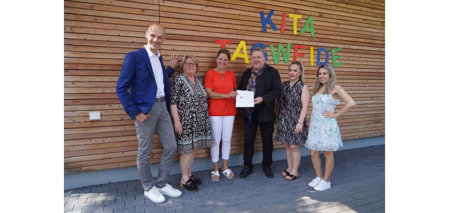 Der hauptamtliche Kreisbeigeordnete und zuständige Dezernent Matthias Schimpf (Mitte) überreichte gemeinsam mit Verena Weiß (rechts daneben) vom Bergsträßer Jugendamt den Förderbescheid für die Zwingenberger Kita Tagweide an Bürgermeister Holger Habich (links), die Erste Stadträtin Karin Rettig (rechts daneben), die Kita-Leiterin Anna Malki (rechts daneben) und die stellvertretende Leiterin Annette Di Turi (rechts).