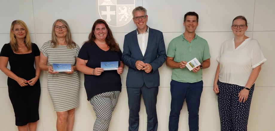 Landrat Christian Engelhardt (3.v.re.) überreicht den drei Gewinnerinnen und Gewinnern Dr. Sandra Thullner, Katharina Becker, Oliver Jägle (v.l.n.r., mit den Gutscheinen in der Hand) im Rahmen der Bergsträßer Bildungsumfrage ihre Segelflug-Gutscheine. Mit dabei: Corinna Simeth, Leiterin der Abteilung Grundsatz und Kreisentwicklung beim Kreis (ganz links) sowie Barbara Meyer, Sachbearbeiterin im Fachbereich Bildung der Kreisverwaltung (ganz rechts).