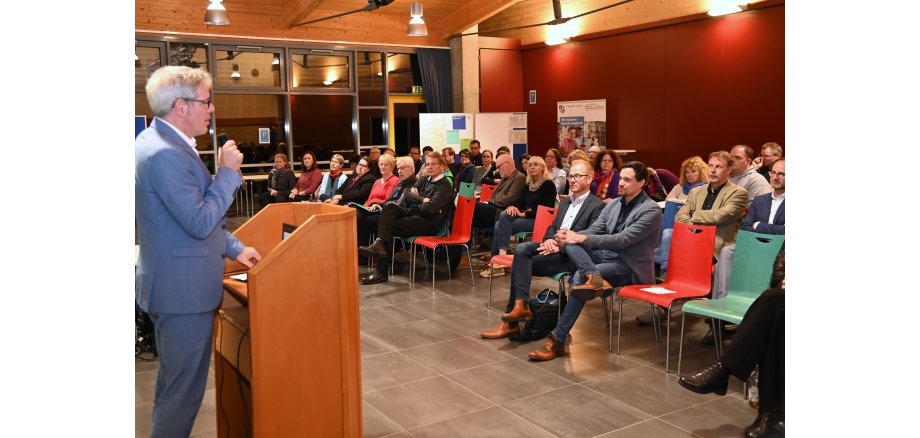 Bei der Regionalkonferenz für das Ried inkl. Viernheim zum Schulentwicklungsplan: Landrat Engelhardt am Podium vor den sitzenden Teilnehmenden.