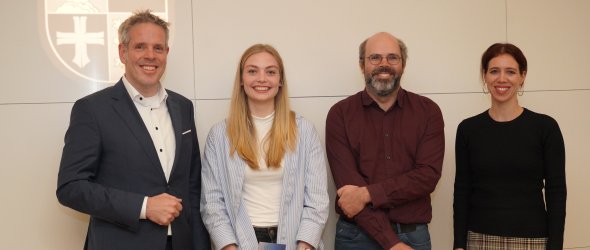 Landrat Christian Engelhardt steht mit den Gewinnern Kira Marie Gabel und Max Bade sowie Tanja Malko, Bildungskoordinatorin im Projekt Bergsträßer Bildungskommune vor dem Logo des Kreises Bergstraße.