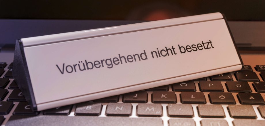 Ein Schild mit der Aufschrift "Vorübergehend nicht besetzt" steht auf einer Computertastatur.