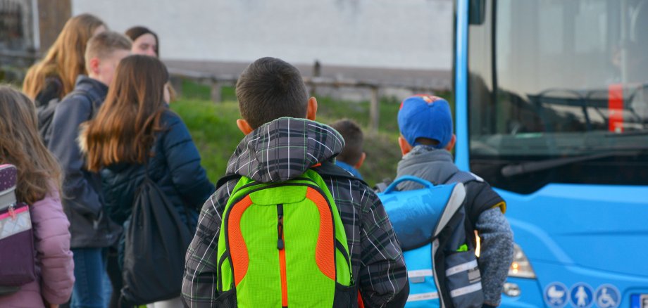 Schüler mit Schulrucksack der Grundschule auf dem morgendlichen Weg zum Schulbus